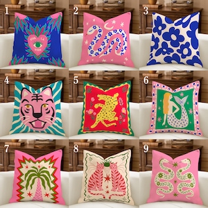 Op de afbeelding: Een verzameling decoratieve kussens met levendige ontwerpen. Kussens tonen verschillende patronen, waaronder een slang, tijger, bloemen en een zeemeermin. Kleuren zijn roze, blauw, groen en rood. Elk kussen heeft een uniek, opvallend ontwerp, perfect voor een vleugje kleur.