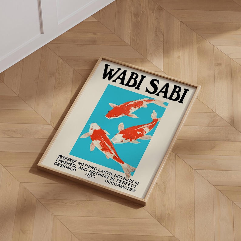 May include: A framed art print featuring the words "WABI SABI" in black above three koi fish illustrations. The fish are red and white against a light blue background. The print also includes Japanese text and the phrase "NOTHING LASTS, NOTHING IS FINISHED, AND NOTHING IS PERFECT."