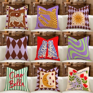 May include: Nine decorative throw cushions with diverse designs. Cushions feature a cheetah, tigers, sun, geometric patterns, and text. Colours include purple, red, green, brown, and cream. The cushions are square and appear to be made of fabric.