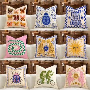 Puede incluir: Una colección de cojines decorativos con varios diseños. Los cojines presentan patrones de mariposas, escarabajos, tigres, serpientes, guepardos, sol, ranas y leopardos. Los colores incluyen rosa, azul, amarillo y verde. Los cojines son cuadrados y parecen ser de tela.