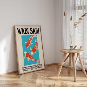 May include: A framed art print with the words "WABI SABI" in large black letters. The print features three orange and white koi fish on a turquoise background. The bottom of the print has Japanese text and the words "NOTHING LASTS, NOTHING IS FINISHED, AND NOTHING IS PERFECT."