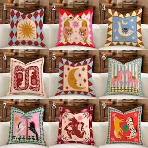 Puede incluir: Una colección de nueve cojines decorativos con varios diseños. Los cojines presentan colores vibrantes y patrones únicos, incluyendo soles, leones, lunas, caras, caballos y figuras abstractas. Cada cojín tiene un borde distintivo y se muestra en un sofá blanco.