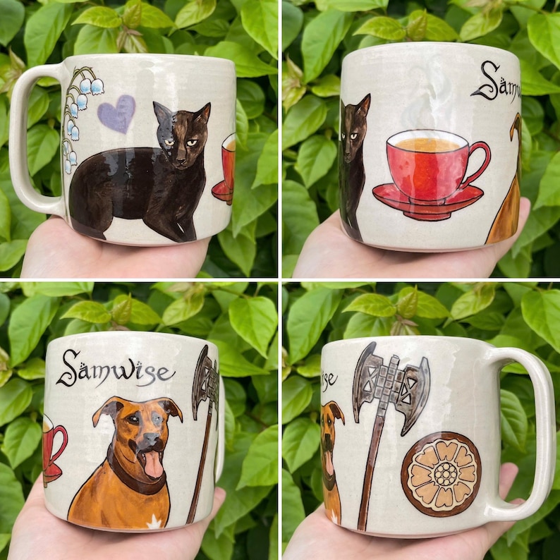 May include: Four ceramic mugs with unique hand-painted designs. One mug features a black cat, another a red teacup, and two depict a dog with an axe. Each mug has a cream-colored base and a large handle.