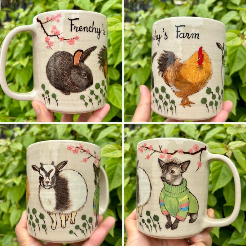 May include: Cream-colored ceramic mugs with animal illustrations. One mug features a rabbit, another a rooster, a goat, and a dog in a green sweater. Each mug has the text "Frenchy's" or "Frenchy's Farm" and floral accents.