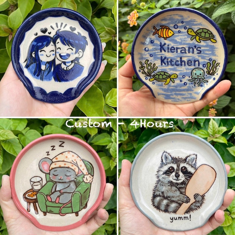 K&ouml;nnte beinhalten: Vier Keramik-L&ouml;ffelablagen mit einzigartigen Designs. Eine zeigt ein Paar, eine andere hat "Kieran's Kitchen" mit Meeresbewohnern, eine dritte zeigt eine schlafende Maus und die letzte einen Waschb&auml;ren mit einem L&ouml;ffel. Der Text "Custom - 4 Hours" ist ebenfalls sichtbar.
