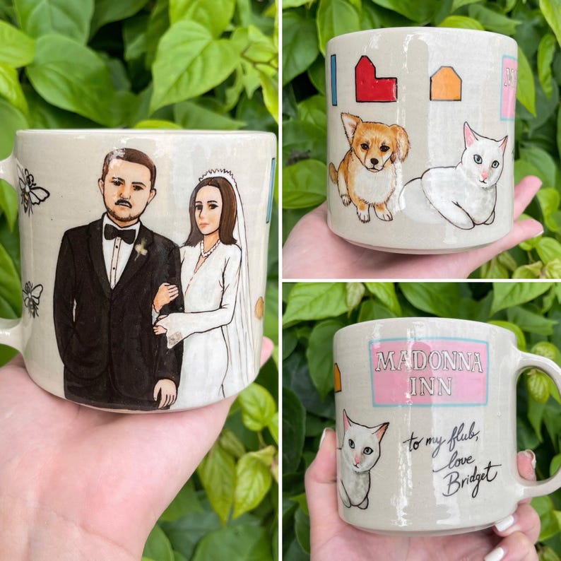May include: Hand-painted ceramic mugs with unique designs. One mug features a couple in wedding attire, another has a corgi and a cat, and the third mug says "Madonna Inn" with a cat illustration and a handwritten message.
