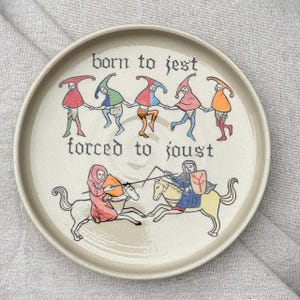 May include: A handmade wooden sign with the word "Welcome" in a whimsical font. It has a distressed white background and a dark brown frame. Dimensions are roughly 30 cm wide and 15 cm high.