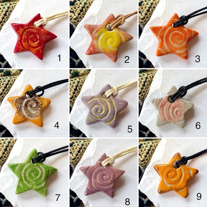May include: A selection of star-shaped ceramic pendants in various colours, including red, orange, yellow, green, and purple. Each pendant features a spiral design and is strung on a cord. The pendants are handmade and suitable for jewellery.