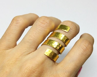 May include: A gold-toned metal ring featuring a spiral design that wraps around the finger. The band has a textured, hammered surface finish and consists of four distinct, overlapping coils that create a continuous, layered appearance.
