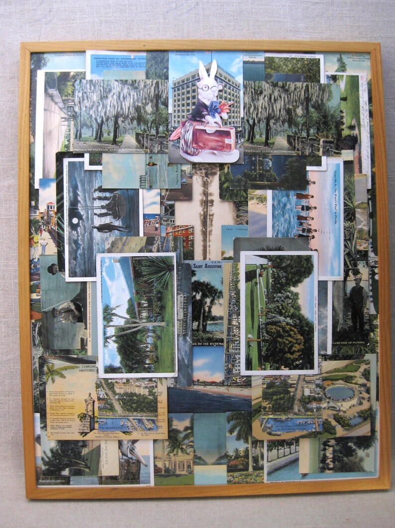 May include: A framed collage of vintage postcards featuring various scenes of Saint Augustine, Florida. The postcards are arranged in a random pattern and include images of the city's historic architecture, beaches, and streets. A small white rabbit figurine is placed on top of the collage.