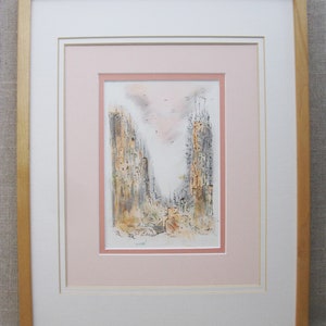 May include: A framed black and white ink drawing of a city scene with tall buildings and a pink sky. The drawing is matted in pink and white and framed in a light wood frame.