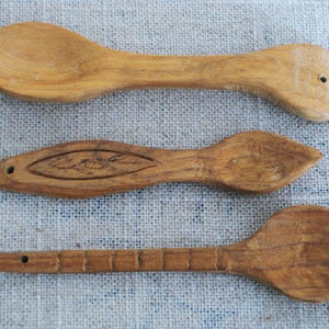 Peut inclure: Trois cuill&egrave;res en bois de diff&eacute;rentes tailles et formes. Les cuill&egrave;res sont en bois brun clair et ont une finition naturelle. Les cuill&egrave;res sont dispos&eacute;es en rang&eacute;e du haut vers le bas, la plus grande cuill&egrave;re en haut et la plus petite cuill&egrave;re en bas.