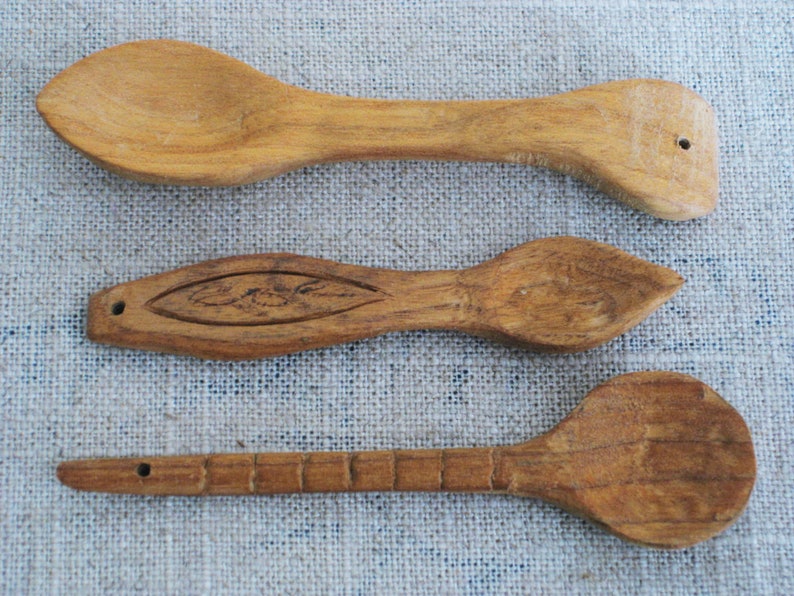 Peut inclure: Trois cuill&egrave;res en bois de diff&eacute;rentes tailles et formes. Les cuill&egrave;res sont en bois brun clair et ont une finition naturelle. Les cuill&egrave;res sont dispos&eacute;es en rang&eacute;e du haut vers le bas, la plus grande cuill&egrave;re en haut et la plus petite cuill&egrave;re en bas.