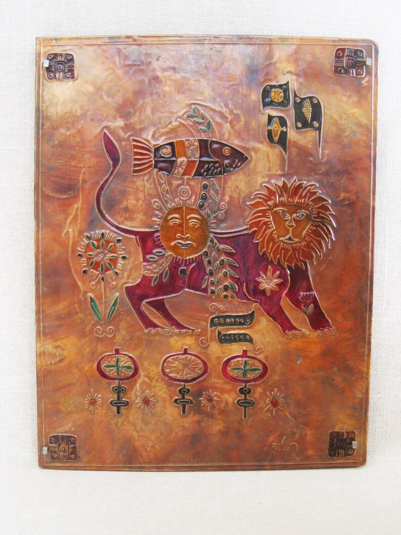 May include: A copper wall hanging with a stylized lion, sun, and fish design. The lion is red, the sun is yellow, and the fish is black, white, and red. The background is a mottled copper color.