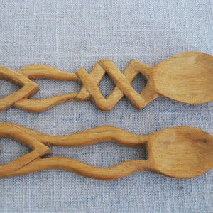 Peut inclure: Deux cuill&egrave;res en bois avec des manches en forme de c&oelig;ur. Les cuill&egrave;res sont sculpt&eacute;es avec des motifs complexes et ont une finition en bois naturel.