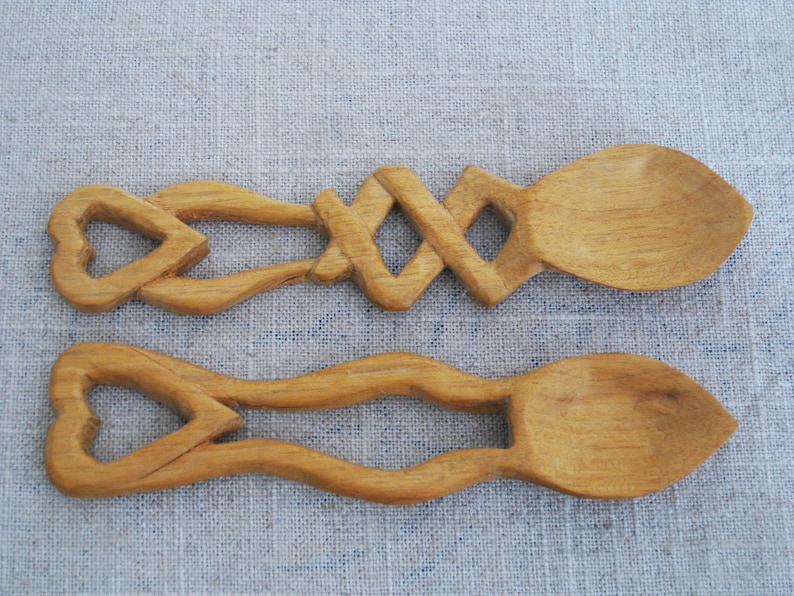 Peut inclure: Deux cuill&egrave;res en bois avec des manches en forme de c&oelig;ur. Les cuill&egrave;res sont sculpt&eacute;es avec des motifs complexes et ont une finition en bois naturel.
