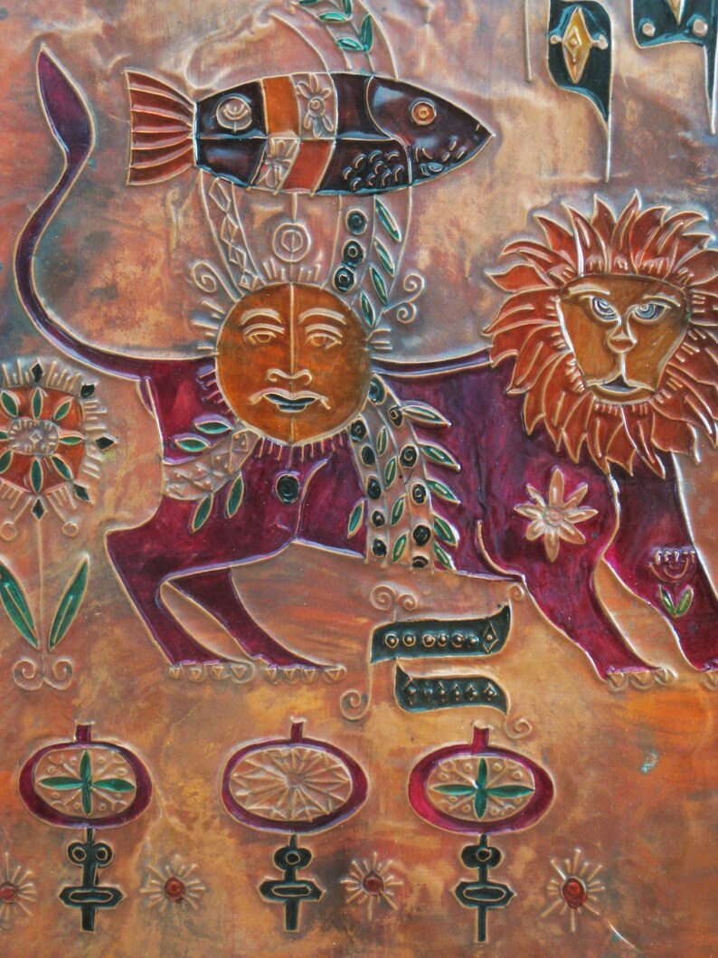 May include: A copper relief sculpture with a lion, a sun, and a fish. The lion is red, orange, and brown. The sun is yellow and has a human face. The fish is black, orange, and white. The background is a copper color with a floral design.