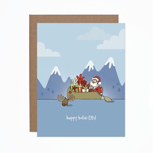 May include: A Christmas card illustration of Santa Claus in a canoe laden with presents, with a moose swimming alongside. Mountains and the words "happy holid-Elfs!" are in the background.