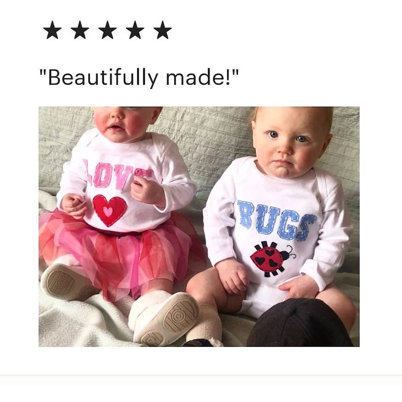 May include: Two babies wearing white long-sleeved onesies. One onesie has the word "LOVE" with a pink heart and the other onesie has the word "BUGS" with a red ladybug.