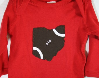 May include: Red long-sleeved shirt with a brown felt appliqué of the state of Ohio shaped like a football.
