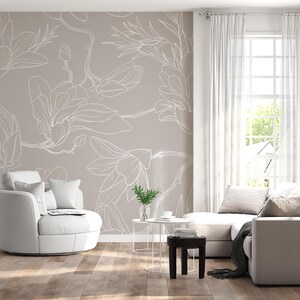 May include: A modern living room with a neutral color palette. Features a beige floral wallpaper, white curtains, a white sectional sofa, and a white swivel chair. A small side table and a dark brown stool complete the space.