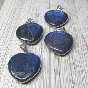 Puede incluir: Cuatro colgantes de lapisl&aacute;zuli en forma de coraz&oacute;n con engastes de plata. Los colgantes son de color azul oscuro con vetas blancas y est&aacute;n listos para ser enhebrados en un collar o pulsera.