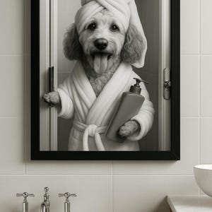 May include: Black and white framed print of a dog in a spa setting. The dog is wearing a white robe and towel, holding a bottle of soap. The dog is sticking its tongue out. The print is hanging in a bathroom with a white tub.
