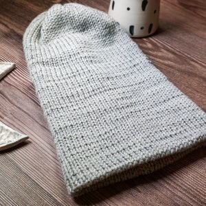 grey knit hat laying down on wood surface