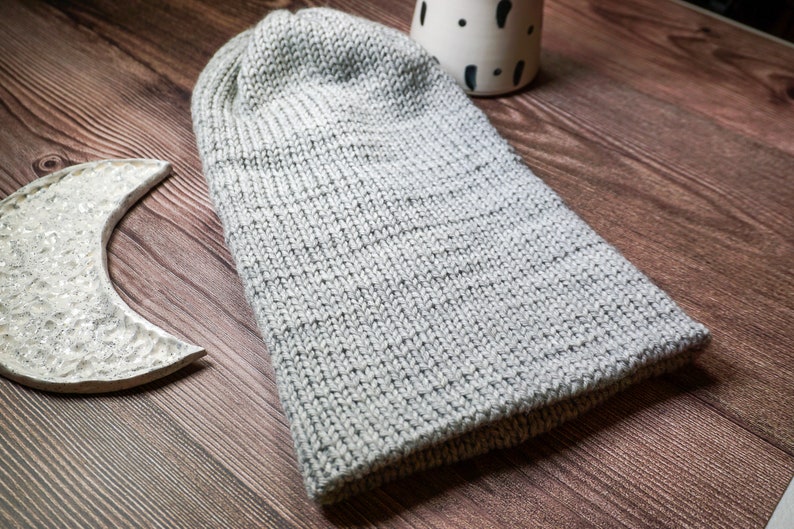 grey knit hat laying down on wood surface