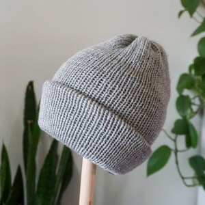Grey knit hat on hat form