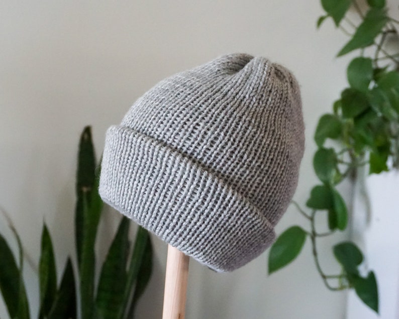 Grey knit hat on hat form