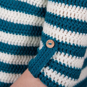 Closeup of crochet jumper sleeve with button and loop