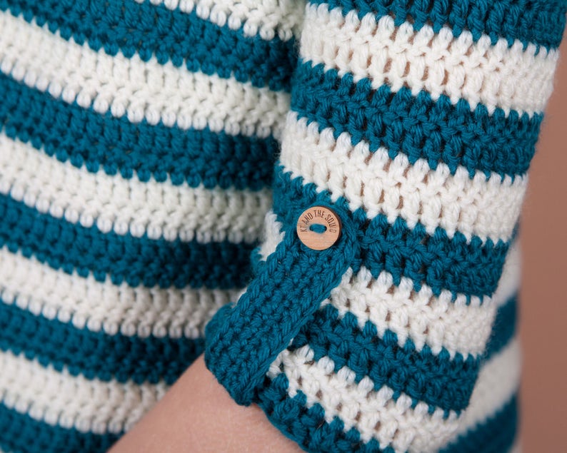 Closeup of crochet jumper sleeve with button and loop