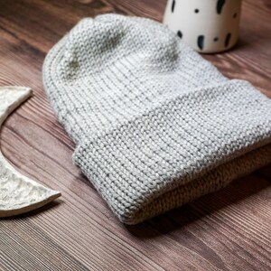 grey knit hat laying down with brim folded over