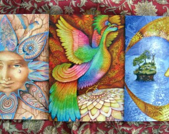 May include: Three colourful paintings on canvas, each depicting a different celestial body. The first painting features a sun with a tear rolling down its cheek, surrounded by intricate floral patterns. The second painting shows a vibrant, rainbow-coloured bird with a long, flowing tail. The third painting depicts a crescent moon with a star and a small island in the background.