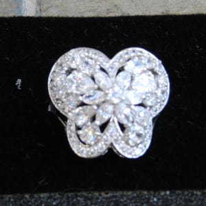 May include: A silver butterfly ring with clear cubic zirconia stones.