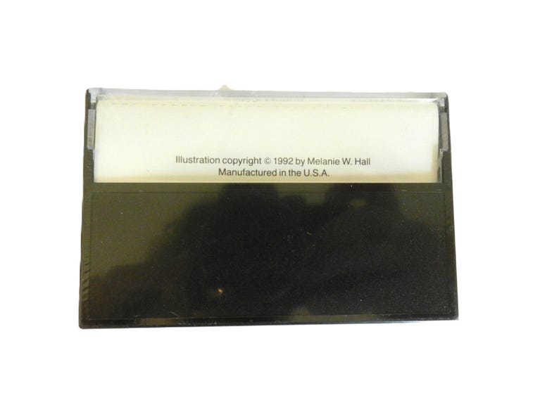 May include: A black cassette tape case with a white label that reads "Illustration copyright &copy; 1992 by Melanie W. Hall. Manufactured in the U.S.A."