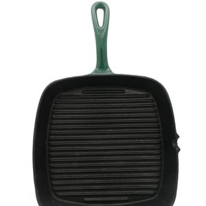 May include: A square cast iron grill pan with a black interior featuring horizontal ridges and a glossy dark green enameled exterior. The pan includes a long, sturdy handle with a hole for hanging and a small pouring spout on the side edge.