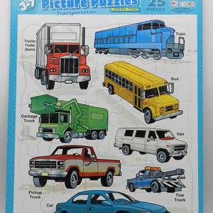 May include: A 25-piece jigsaw puzzle featuring various transportation vehicles. The puzzle includes a red tractor-trailer, a blue train, a yellow school bus, a green garbage truck, a white van, a red pickup truck, a blue car, and a blue tow truck. The puzzle is designed for ages 3-7.