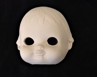 May include: A white ceramic doll head with blank eyes and a closed mouth. The doll head is unfinished and ready to be painted.