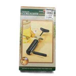 May include: A boxed air pressure cork popper. The box features an image of a wine bottle, a wine glass, and the cork popper. The text on the box reads "Air Pressure Cork Popper" and "Napa Essentials".