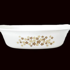 May include: White oval baking dish with a floral pattern in brown and yellow.
