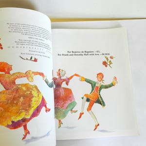 May include: A vintage book with a colorful illustration of three people dancing. The text on the page reads "For Beatrice de Regniers -F.L For Frank and Dorothy Hall with love-M.W.H."