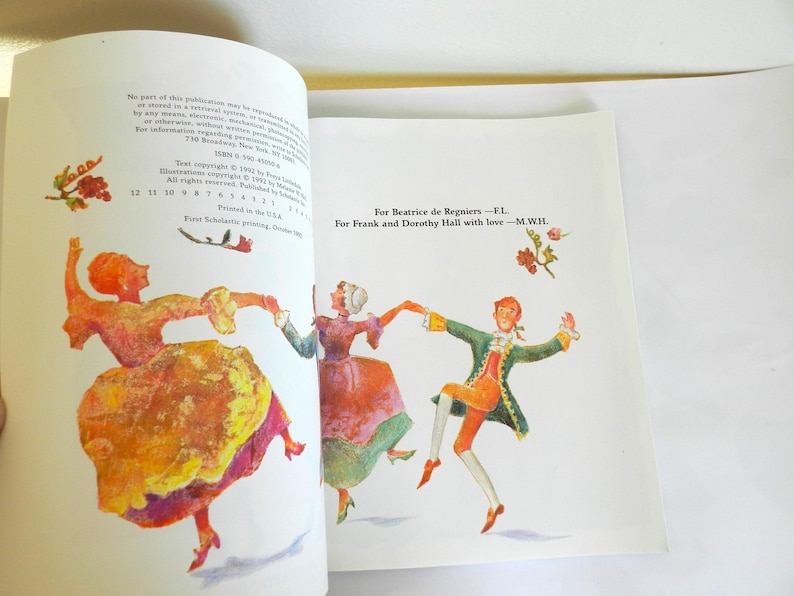 May include: A vintage book with a colorful illustration of three people dancing. The text on the page reads "For Beatrice de Regniers -F.L For Frank and Dorothy Hall with love-M.W.H."