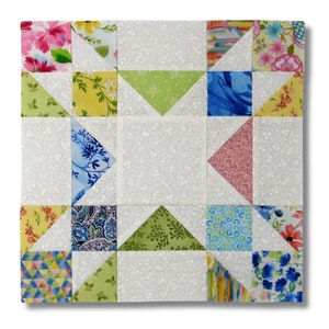 May include: A patchwork quilt block featuring a star design. The block is composed of 16 squares, each with a different floral print fabric. The background fabric is white with a subtle floral pattern.