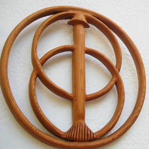 May include: A wooden sculpture featuring three concentric circles and a central vertical post. The sculpture is crafted from light brown wood and has a natural wood finish.