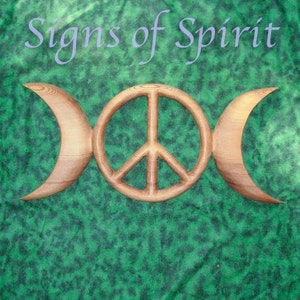 May include: A wooden wall hanging with a peace sign and a triple moon symbol. The peace sign is in the center and the triple moon is on either side of the peace sign. The wood is a light brown color.