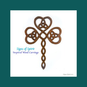May include: A wooden carving of a Celtic knot in the shape of a shamrock. The carving is brown and has a natural wood finish. The carving is a traditional Irish symbol of good luck and prosperity.