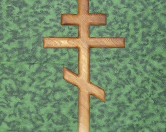 May include: A wooden Orthodox cross with a simple, traditional design. The cross is made of light brown wood and has a smooth, polished finish.