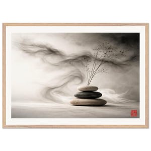 Könnte beinhalten: Gerahmter Druck mit einer Zen-inspirierten Komposition. Drei gestapelte Steine werden von zarten Zweigen gekrönt, vor einem Hintergrund aus weichen, rauchigen grauen Wirbeln. Das Kunstwerk ist in einem hellen Holzrahmen eingefasst.
